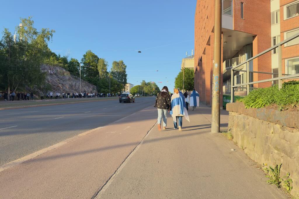 Suomen mm-kultajuhlien yleisöä kotimatkalla Suomen lipun kera